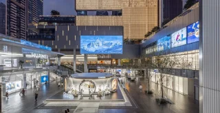 A bustling shopping mall filled with people walking and exploring various stores and attractions.