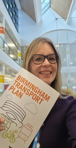 An image of a person holding a copy of the Birmingham Transport Plan booklet.