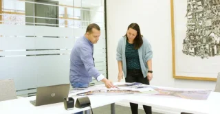 Two individuals collaborating in a office meeting room.