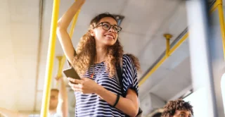 Person using smartphone on public transit interior